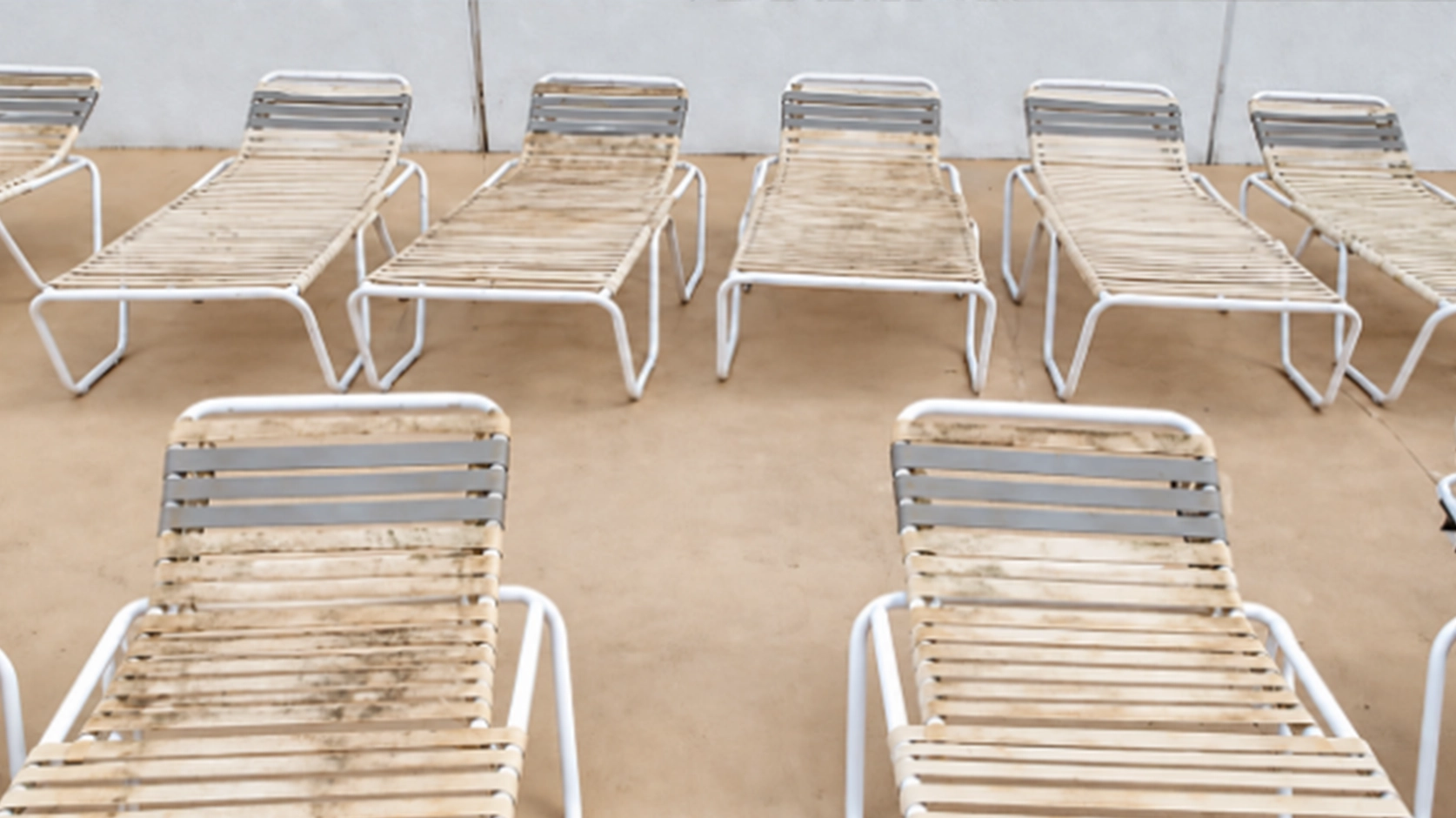 Close-up of vinyl strap patio chair being cleaned with a soft brush and mild soap